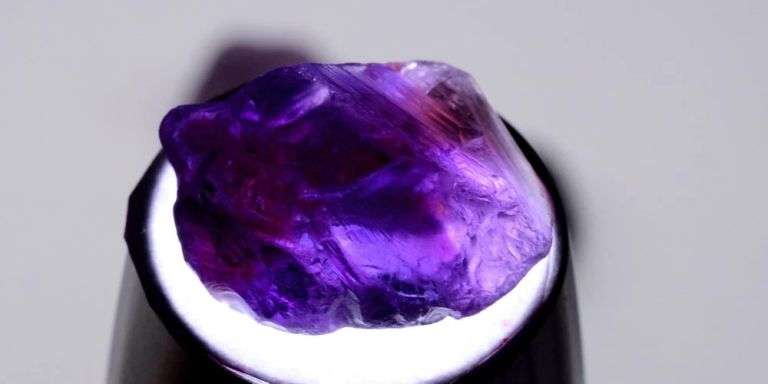 Deep color in this 69.67ct uncut untreated Amethyst set