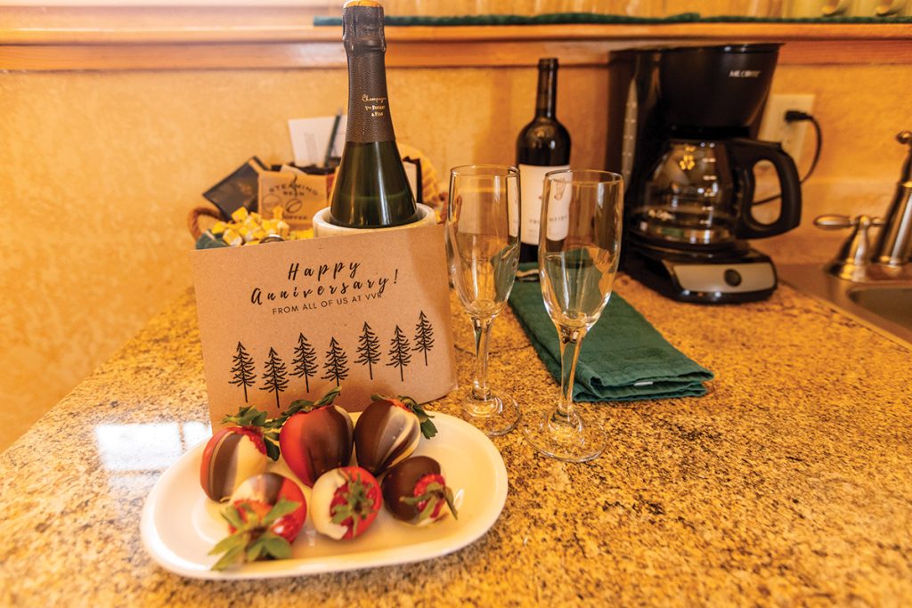 A "Happy Anniversary" display featuring chocolate-covered strawberries and wine.