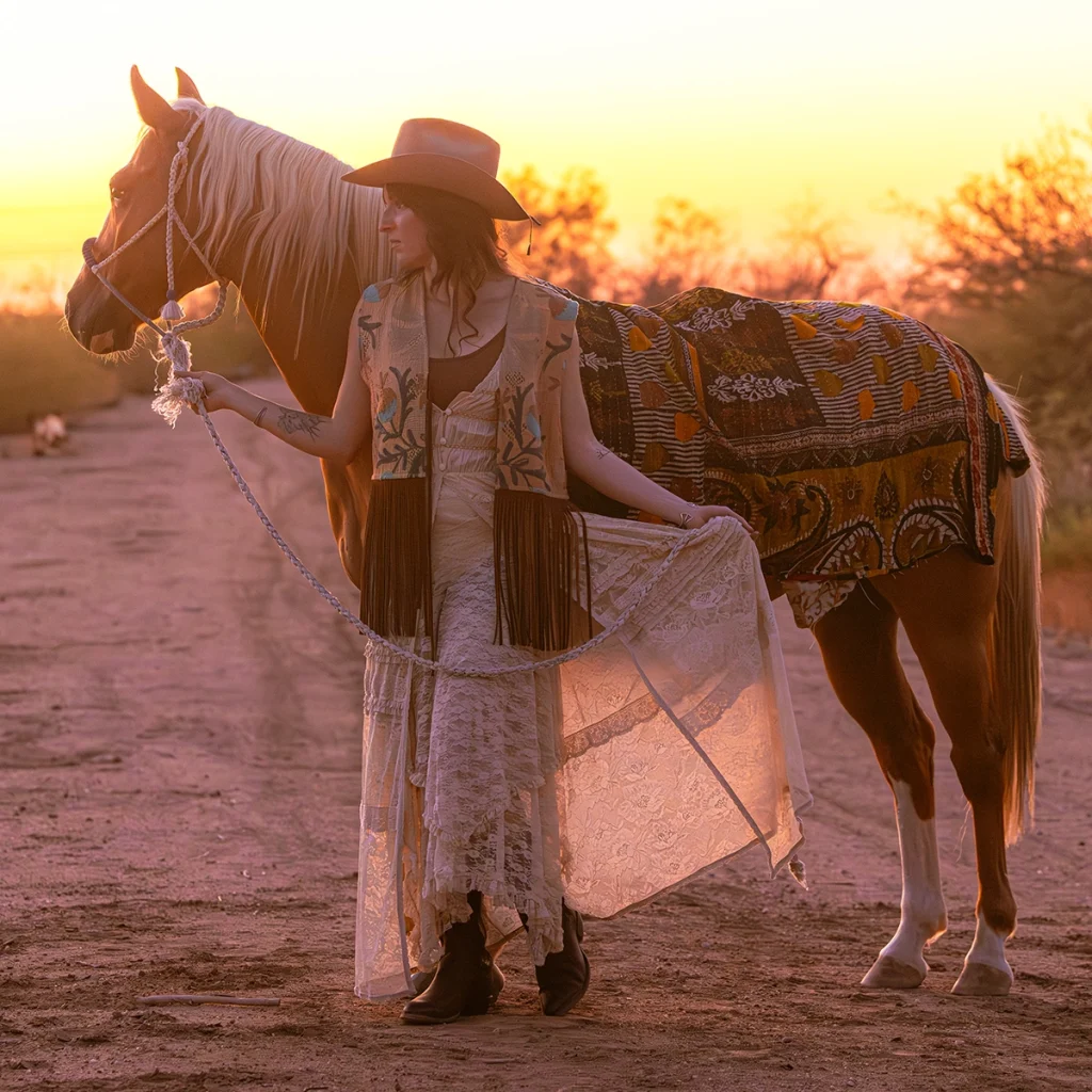 Chelci Schroeder of Wylder Trading Company posing with a horse.