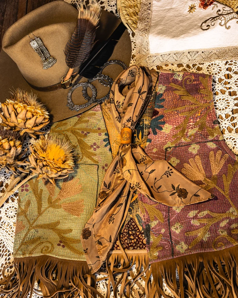 An Artisan Textile Vest, a vintage hat, a silk sari bandanna, a leather bolo, and silver earrings and bangles.
