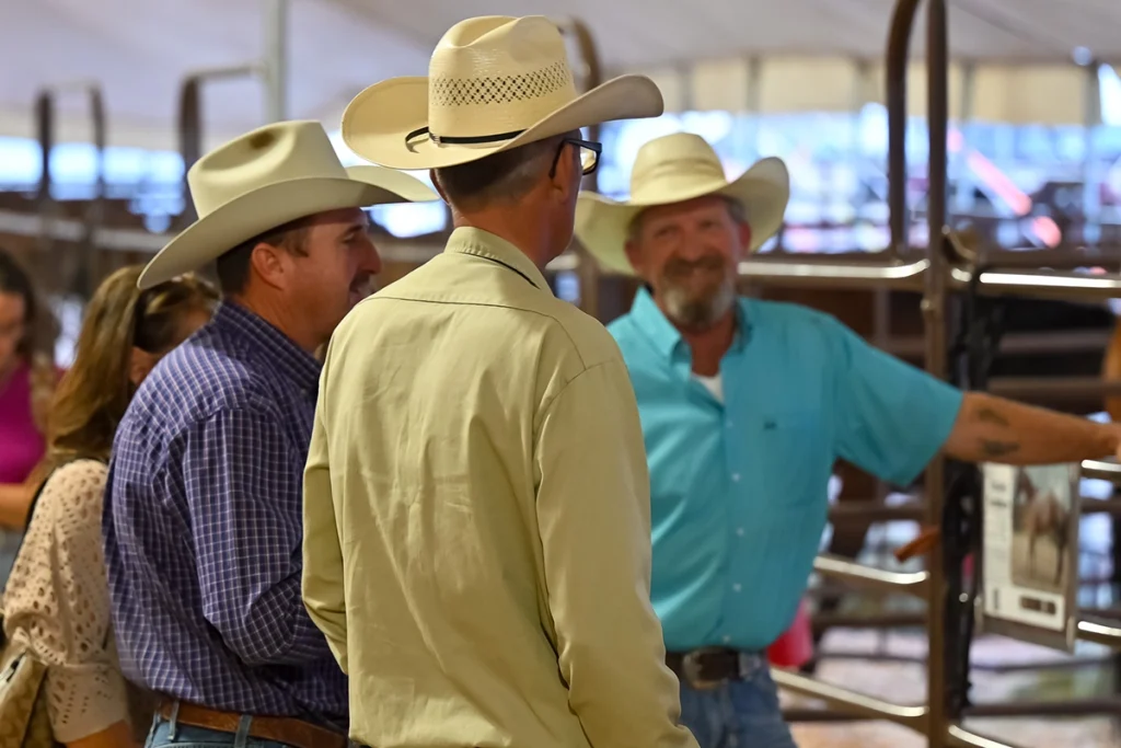 Buyers and sellers talking at a ranch production sale.