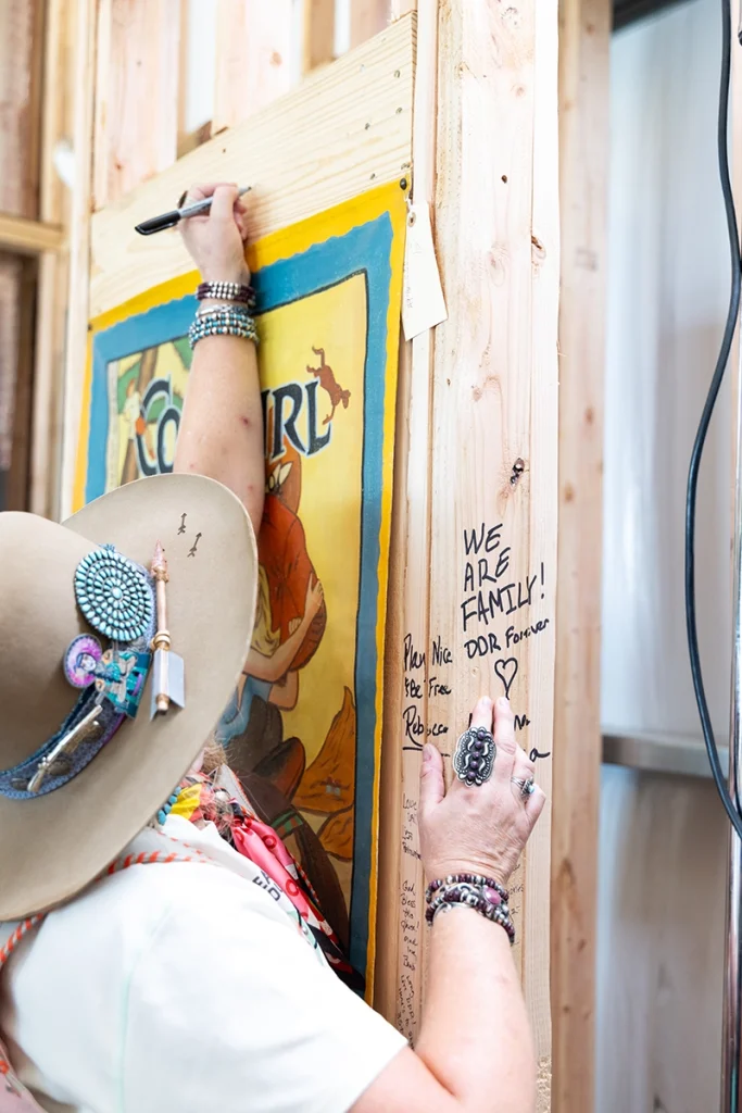 A visitor signs the wall.