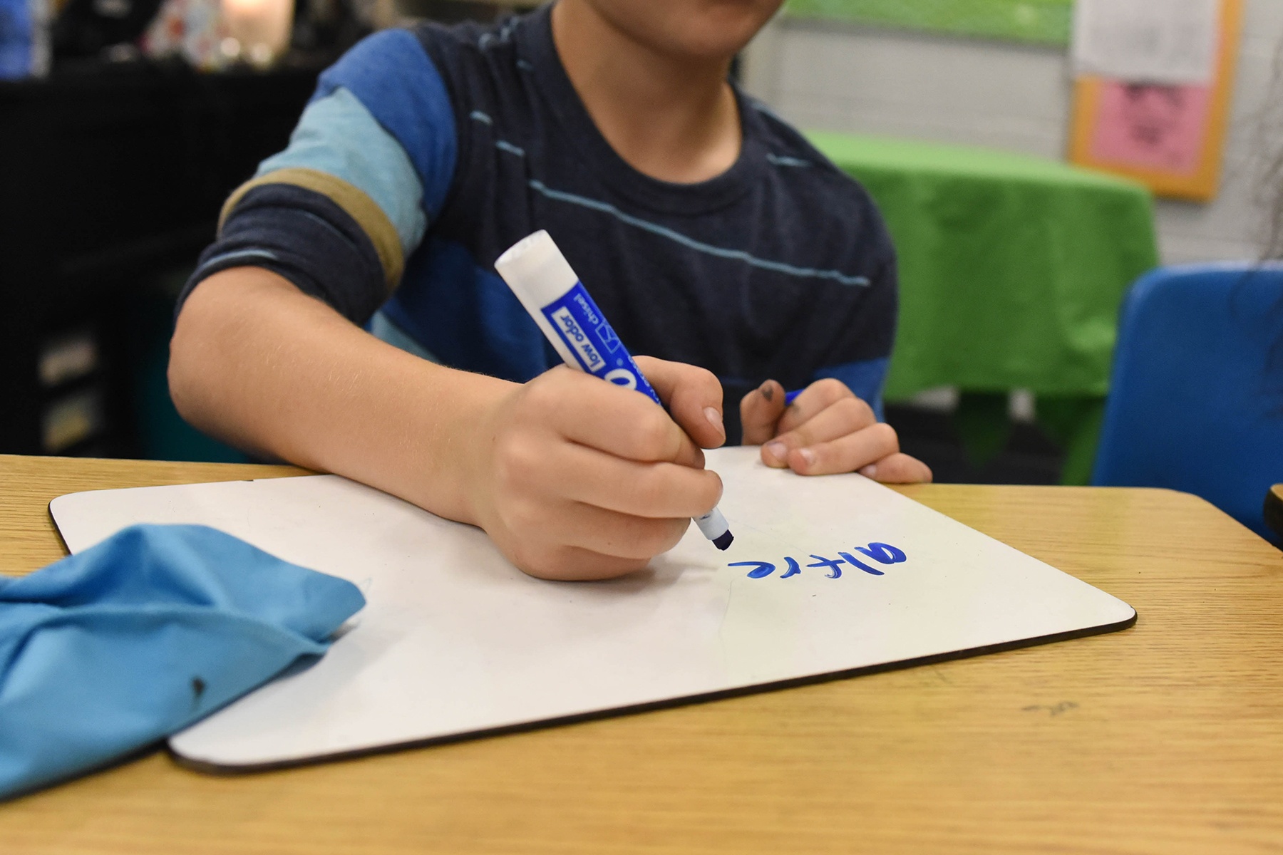 student writing on dry erase board