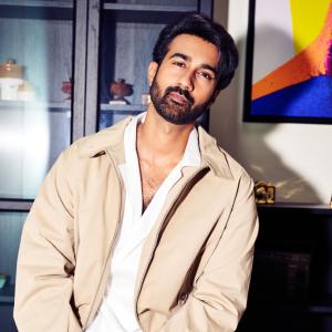 Hero Santosh Shoban Stylish and Confident Look Featuring Bold Art Background