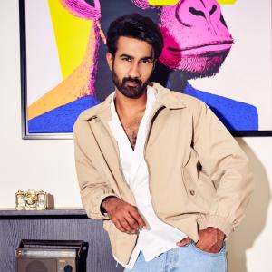 Hero Santosh Shoban Stylish and Confident Look Featuring Bold Art Background