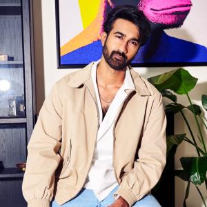 Hero Santosh Shoban Stylish and Confident Look Featuring Bold Art Background