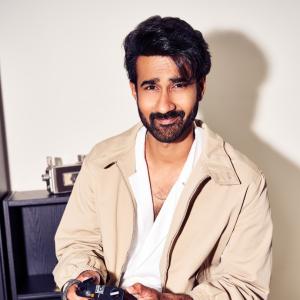 Hero Santosh Shoban Stylish and Confident Look Featuring Bold Art Background