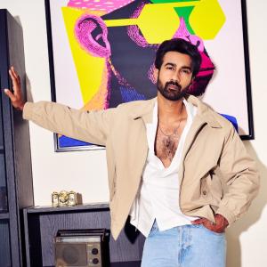 Hero Santosh Shoban Stylish and Confident Look Featuring Bold Art Background