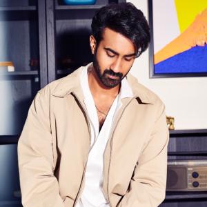 Hero Santosh Shoban Stylish and Confident Look Featuring Bold Art Background