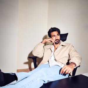 Hero Santosh Shoban Stylish and Confident Look Featuring Bold Art Background