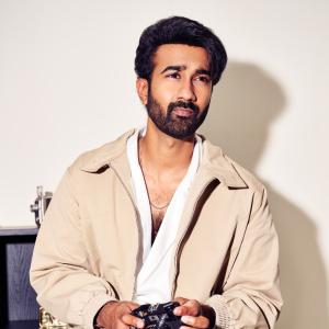 Hero Santosh Shoban Stylish and Confident Look Featuring Bold Art Background