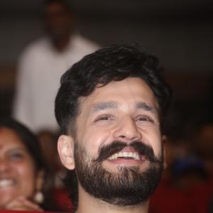 Akhil Akkineni Enjoys a Cheerful Moment at Public Event