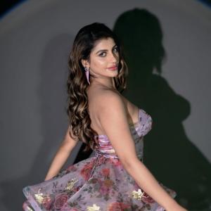 Actress Yashika Anand in Elegant Floral Mini Dress with Purple Tassel Earrings
