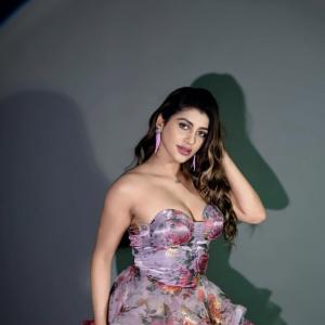 Actress Yashika Anand in Elegant Floral Mini Dress with Purple Tassel Earrings