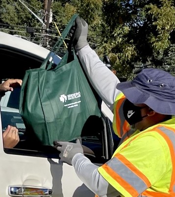 Austin, TX – A volunteer from Austin Public Works helps load a turkey and holiday-meal sides into a car. The turkey and sides were given to elderly, disabled and low-income residents at the Turkey Fest/Fiesta del Pavo event sponsored by Sendero Health Plans and Austin Public Health, Saturday, November 13 at The East Austin Neighborhood Center. Photo Credit: Rodolfo Ybarra, Sendero Health Plans