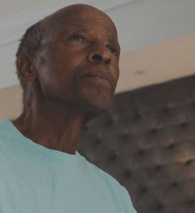 A man sits in a bedroom, looking upward. SSI benefits help people who can't work because of health problems and have limited financial resources.