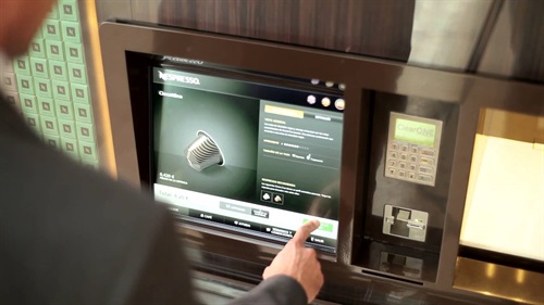 Nespresso - il cliente può prelevare dalla parete le confezioni di caffè desiderate, con il supporto di tutti gli elementi informativi. Lo spazio espositivo si riassortisce in maniera automatizzata. Le confezioni scelte vengono collocate in un sacche