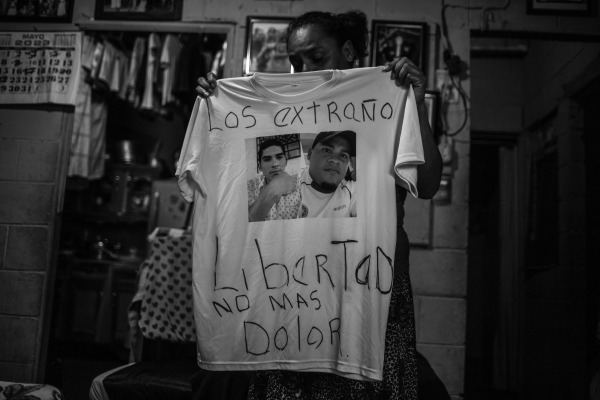 Cecilia Abrego holds a T-shirt with photographs of her sons, who were detained and imprisoned in May 2022. Cecilia has cancer and must find money to send to her sons and for her own treatment. San Salvador, El Salvador, 12 May 2023
