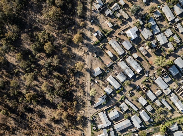 An aerial view of newly constructed homes next to the fence line of Mosi-oa-Tunya National Park. Zambia’s population has nearly tripled since 1990. Livingstone, Zambia, 2 September 2024