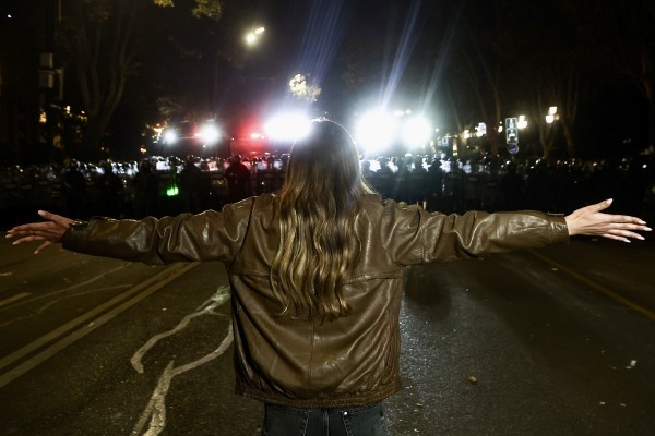 A woman confronts riot police during a rally outside the Parliament of Georgia, on Rustaveli Avenue. Police had brought water cannons onto the avenue to disperse protesters. Tbilisi, Georgia, 7 December 2024