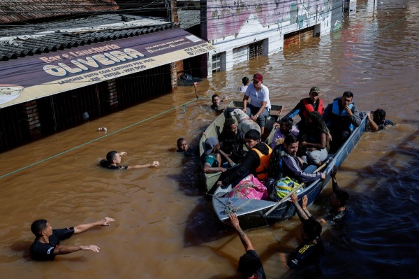 Volunteers use their own boats to rescue people trapped by rising floodwaters. Emergency teams and local volunteers navigated strong currents to evacuate families and pets to safety. Canoas, Brazil, 5 May 2024