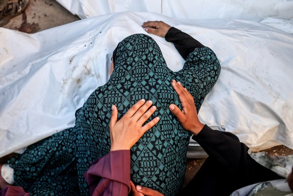 Relatives of people killed in an Israeli attack on the Nuseirat refugee camp mourn as the bodies are brought to al-Aqsa Hospital. Deir al-Balah, Gaza, 9 August 2024