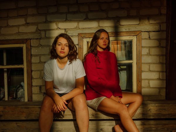 Aliona (left) sits with her younger sister Sanya, a mother of two. Aliona has never talked to Sanya about the war and has no idea of what it must be like to raise a son in wartime Russia. Tomsk, Russia, 5 August 2023