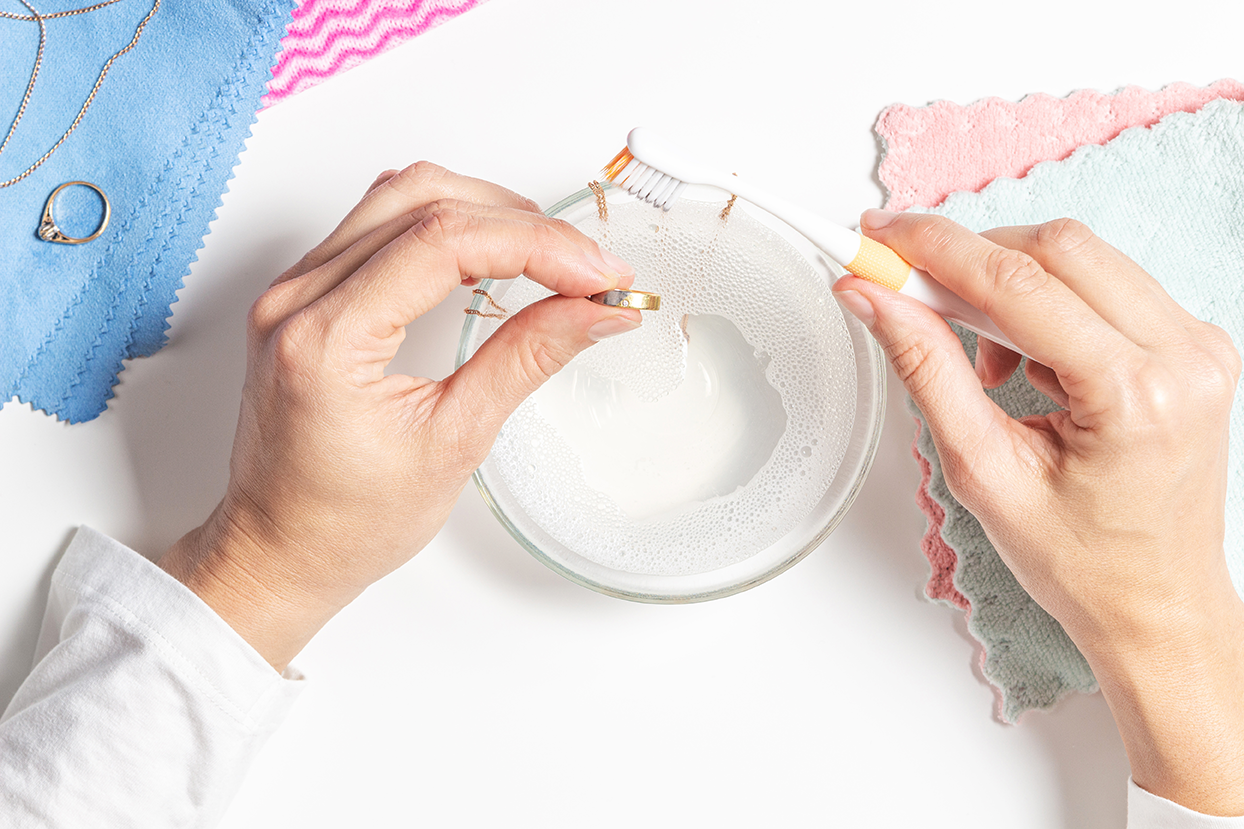 Cleaning fine jewelry in a bowl with a brush