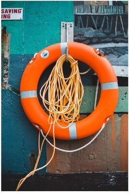  Free to use  Bright lifebuoy with rope hanging on hook