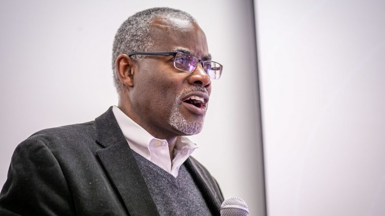 Man speaks holding a microphone.