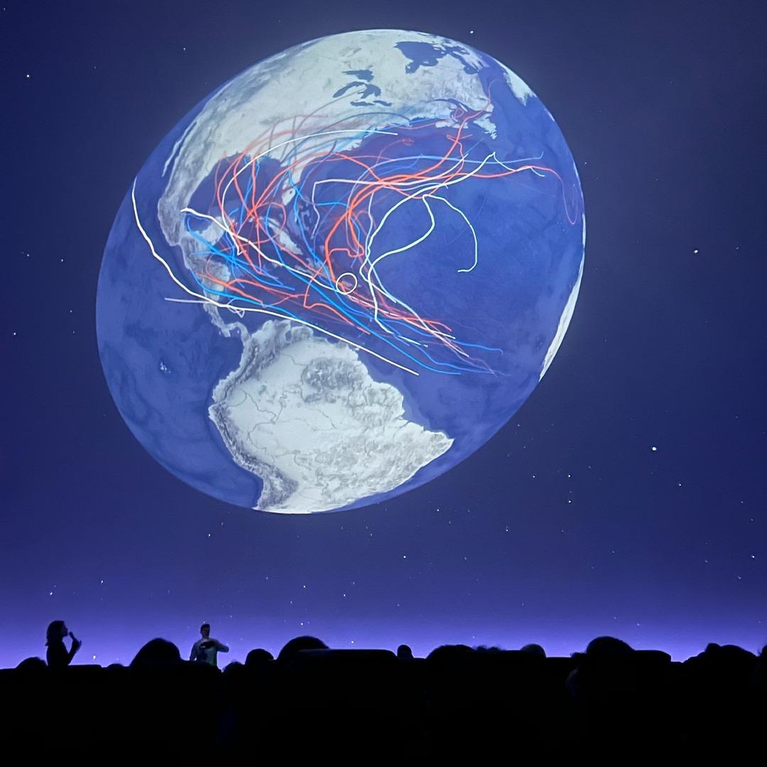 Students at Adler Planetarium’s “Climate Change and Me” exhibit view displays on rising emissions and temperatures.