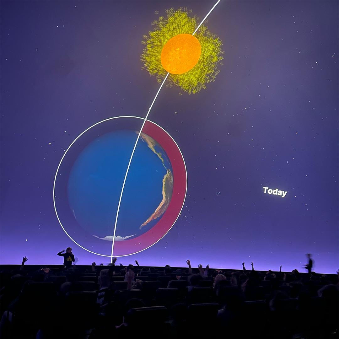 Students at Adler Planetarium’s “Climate Change and Me” exhibit view displays on rising emissions and temperatures.