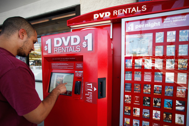 A customer renting a movie from a Redbox kiosk