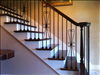 Reclaimed Longleaf Pine Stair Treads blend beautifully with wrought iron railings.