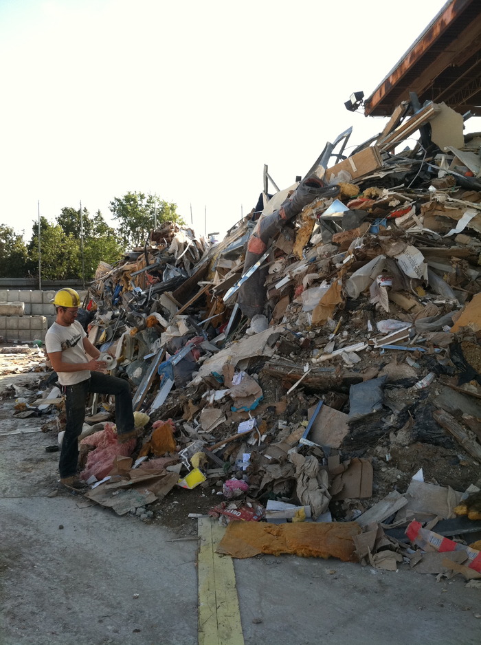 Artist Billy Blaise Dufala scoping the piles of waste for materials.