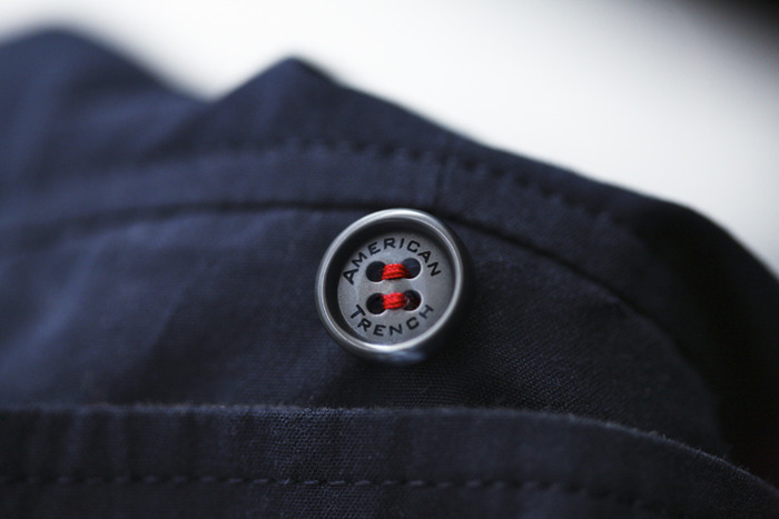 The red thread of the middle button behind the collar is both aesthetic and a design feature