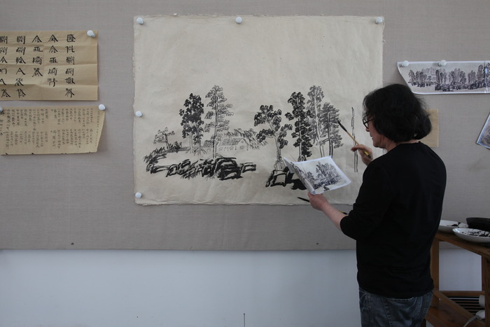 Xu Bing painting a Landscript (a landscape painted using Chinese characters). "Enduring Passion" shows ten great artists at work in their studios. (Photo copyright ©2012 Britta Erickson)