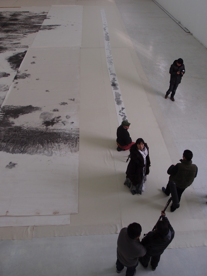 Huang Bingyi showing one of her monumental paintings. Ink is a versatile medium, and "Endless Passion" includes artists working in a wide range of styles. (Photo copyright ©2012 Britta Erickson)