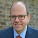 Headshot_by_backyard_brick_wall_cropped_square.small