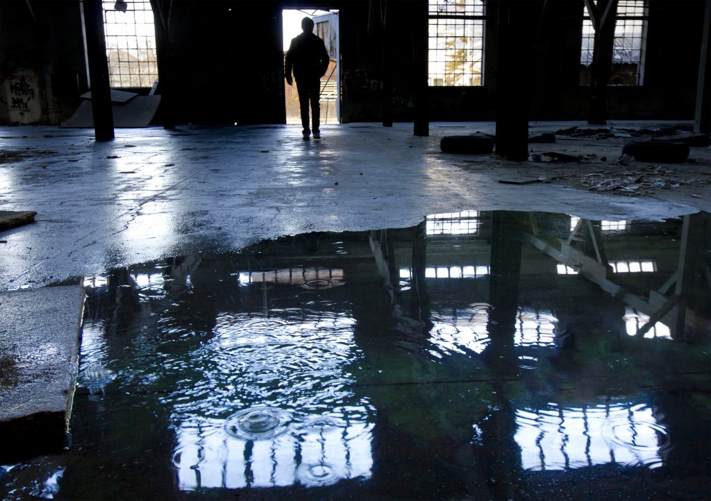 Silhouette of man intră în darkspookyold factory hall 1024x722