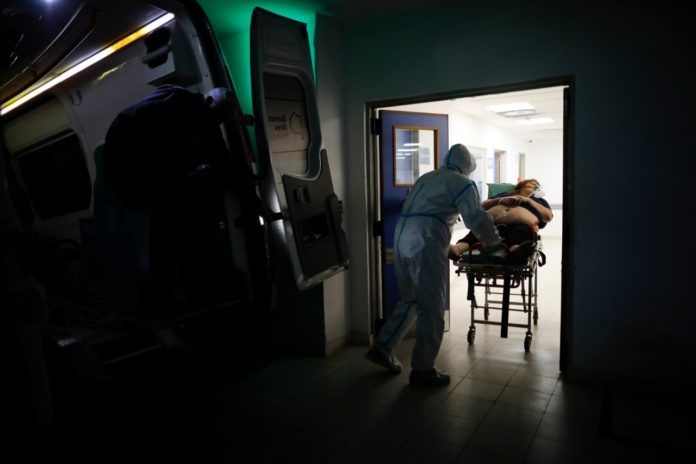 En esta fotografía de archivo, un trabajador de Salud, traslada a una mujer sospechosa de tener COVID-19 en el Hospital Dr. Norberto Raúl Piacentini en Lomas de Zamora, Argentina. Foto La Hora/AP/Natacha Pisarenko.
