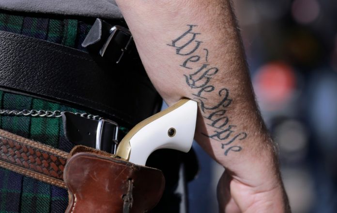 Fotografía de archivo de un partidario de las leyes de posesión libre de armas de fuego con una pistola mientras se prepara para un evento a favor del derecho de posesión en Austin, Texas. Foto La Hora/AP/Eric Gay.