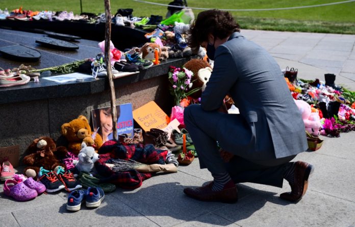 El primer ministro de Canadá Justin Trudeau visita un memorial junto a la Llama Eterna junto al Parlamento en Ottawa, que fue colocado en reconocimiento del descubrimiento de los restos de niños indígenas en el sitio de una antigua escuela residencial en Kamloops, Columbia Británica. Foto La Hora/Sean Kilpatrick/The Canadian Press vía AP.
