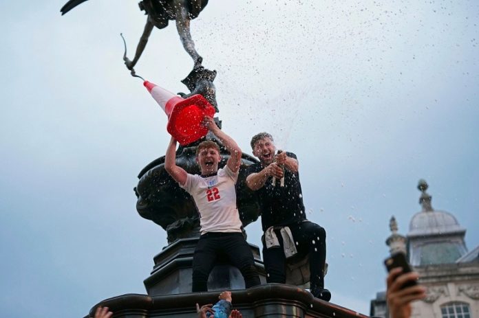 Seguidores de la selección de Inglaterra celebran el pase a cuartos de final tras derrotar a Alemania. Foto La Hora/AP