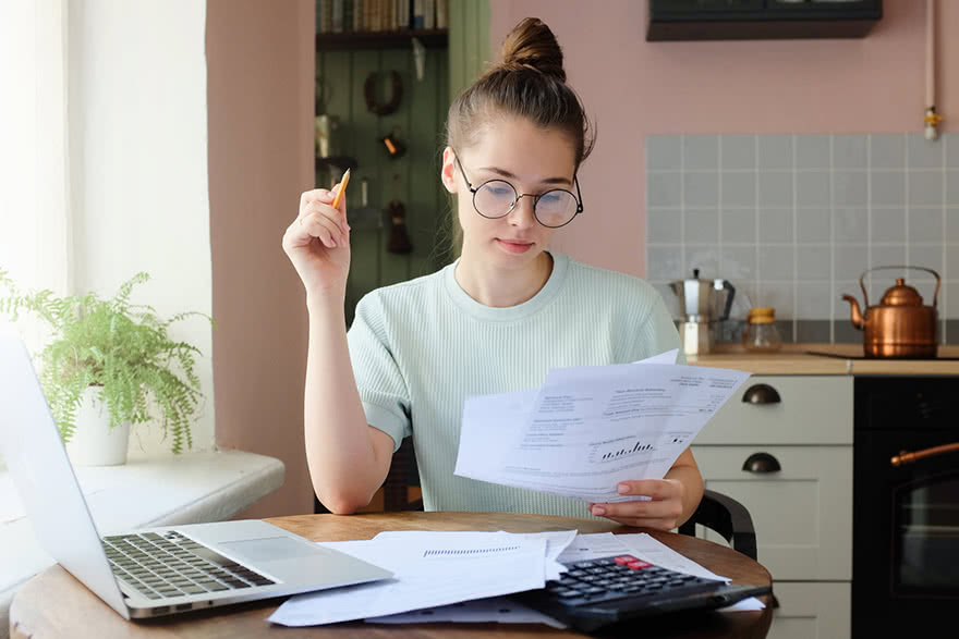 A woman sitting at the kitchen table going over debt