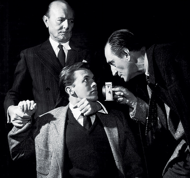 Kilburn, (Walker), is interrogated by Jack Raines (Watson, L) and Basil Rathbone (Sherlock Holmes, R). Written by Rathbone's wife, Ouida, Sherlock Holmes ran on Broadway for three performances in the New Century Theatre, October 30-31, 1953.