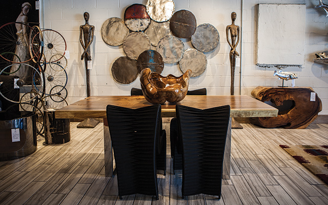 Statement Dining Table: Chamcha wood dining table ($5509), black seatbelt dining chairs ($659 each), skinny female sculpture ($1329), root bowl ($1209), galvanized circle tiles, various colors ($109 each), silver leaf circle tiles, set of 4 ($379). Photo by Mike Hnida