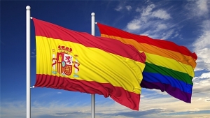 Flag of Spain with LGBTQ+ rainbow flag behind it.