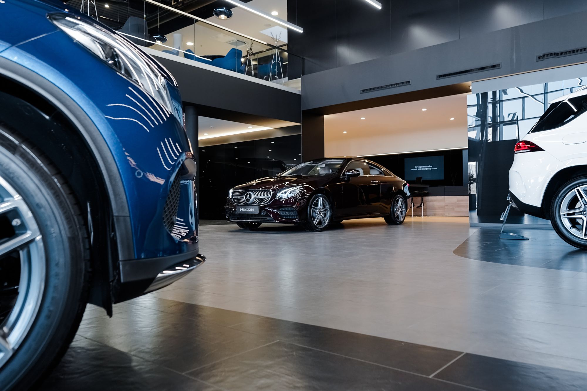 Dealership with black Mercedes and other cars around it.
