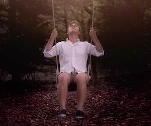 Man in shorts on a swing.